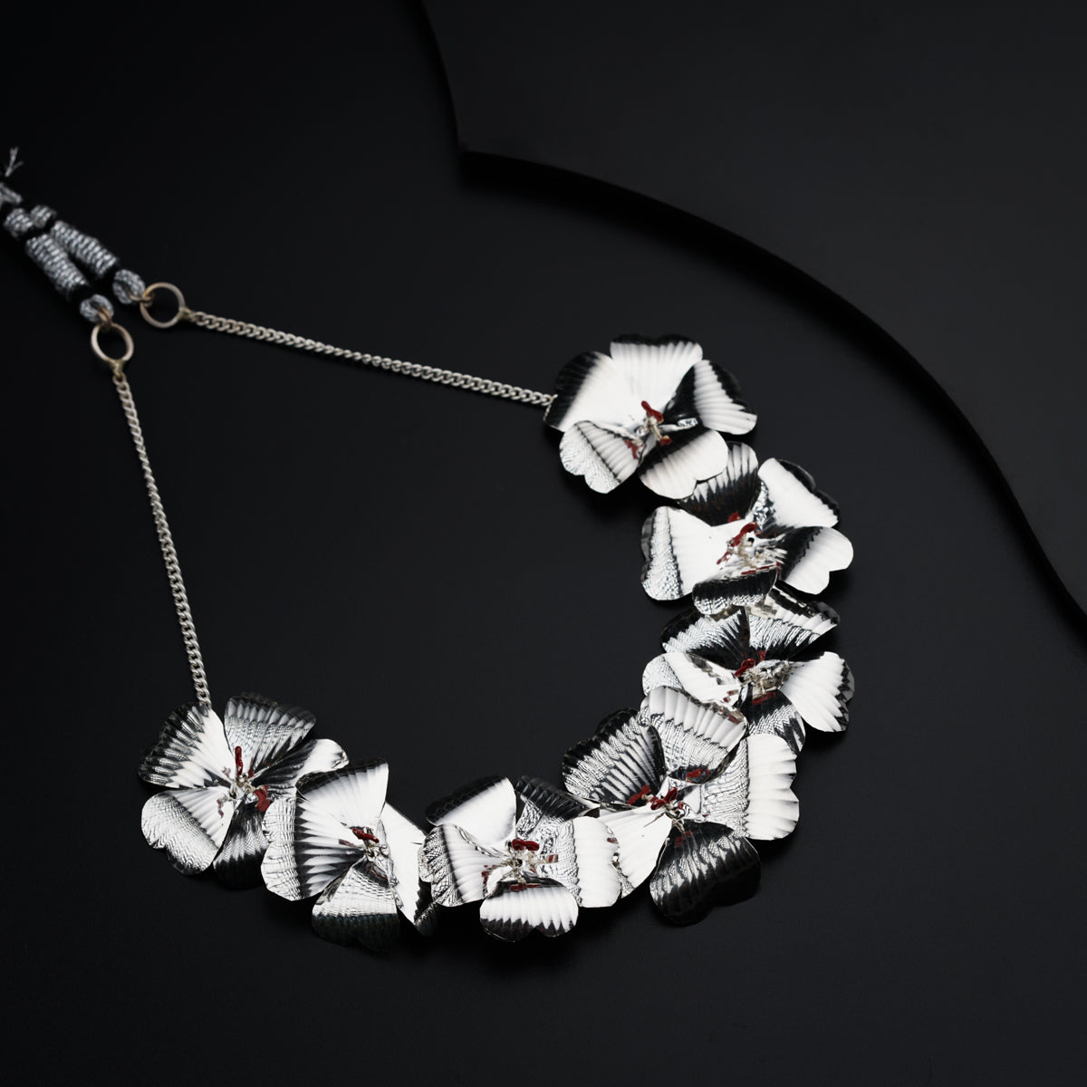 a necklace with white flowers on a black background
