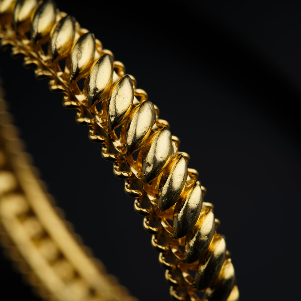 a close up of a gold chain on a black background
