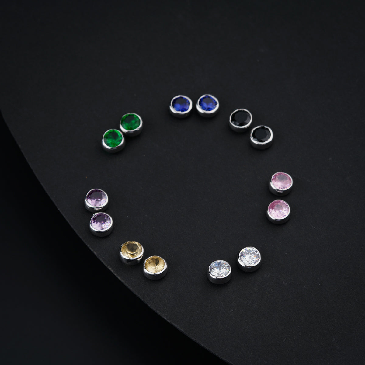 a circle of different colored stones on a black surface