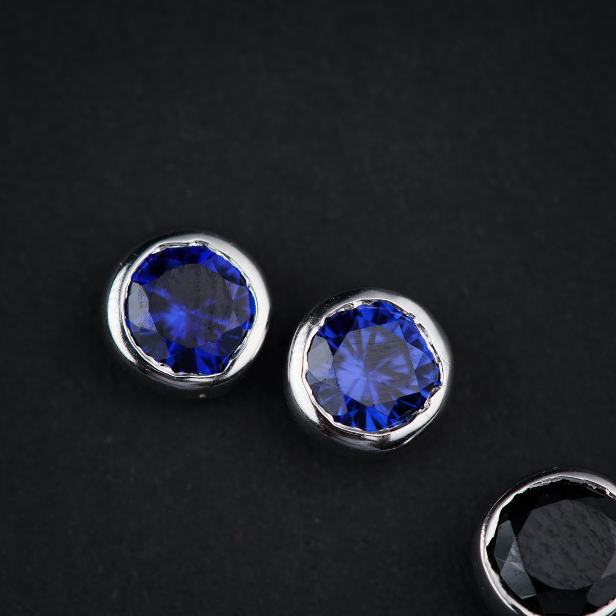 a pair of blue and black diamond earrings