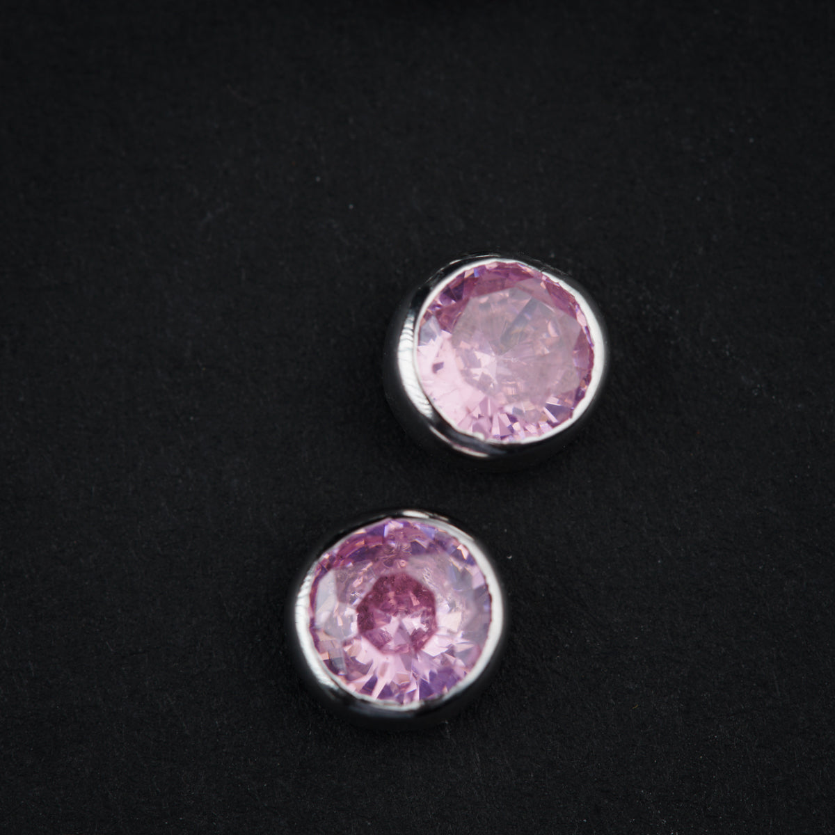 a pair of pink stones sitting on top of a black surface