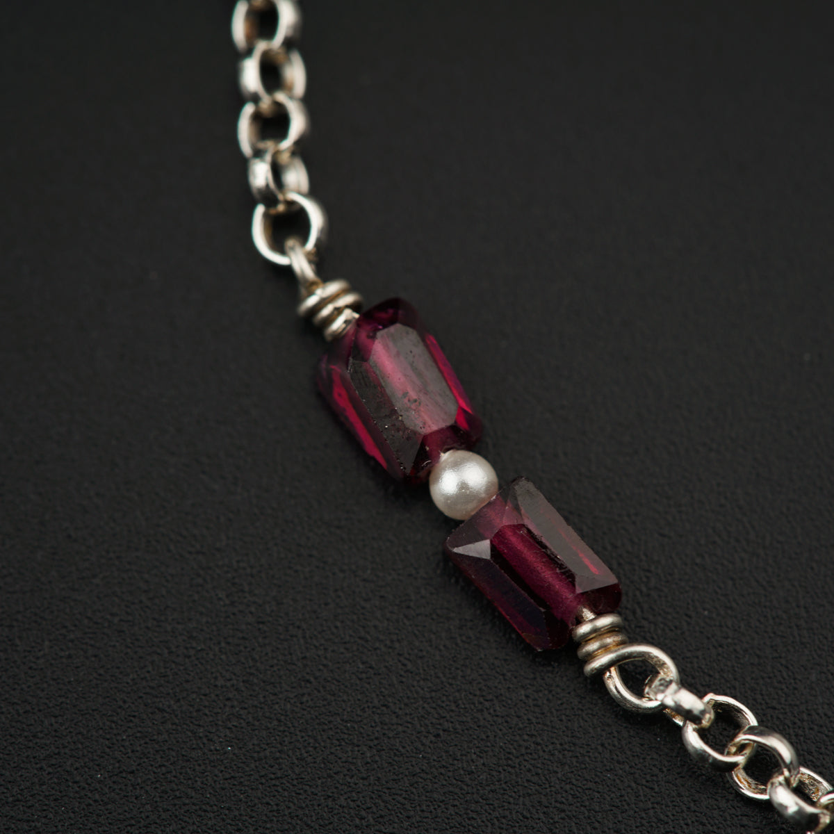 a close up of a necklace on a black surface