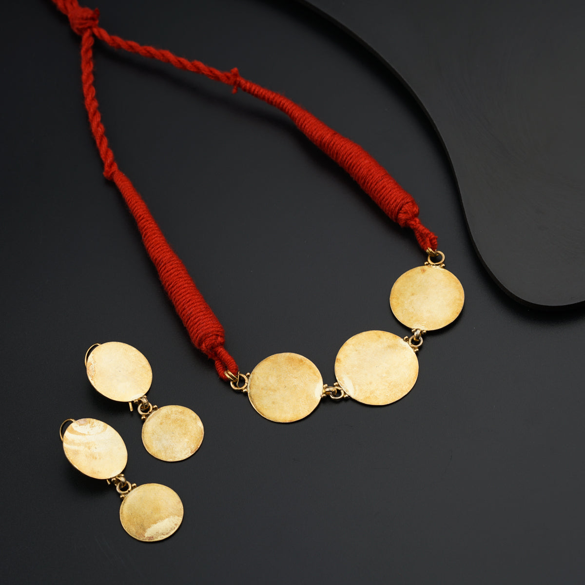 a necklace with five discs on a red cord