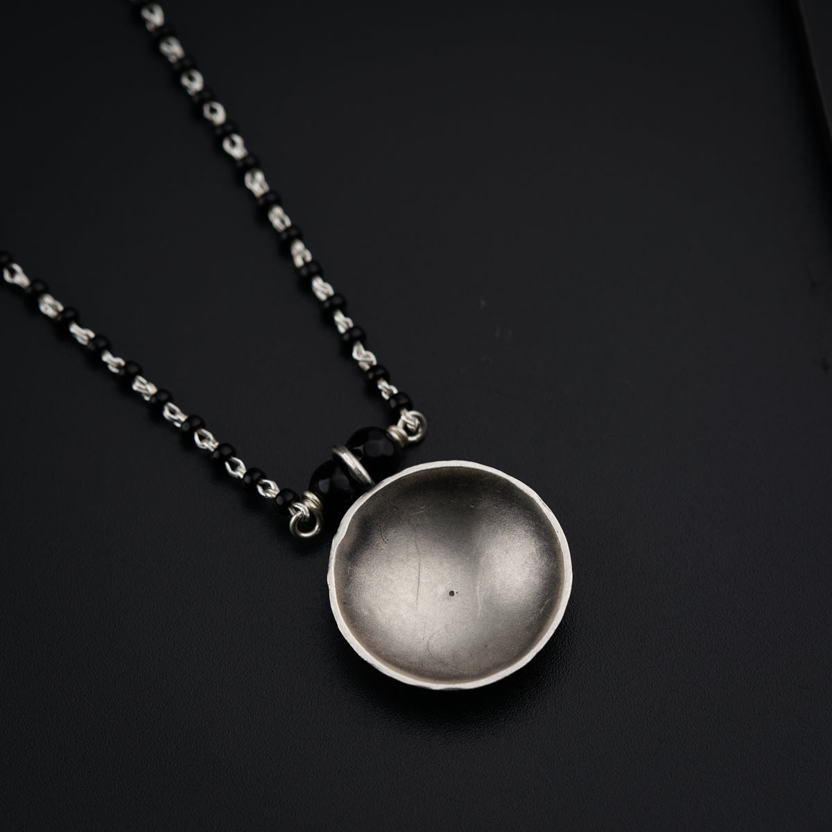 a silver spoon sitting on top of a black table