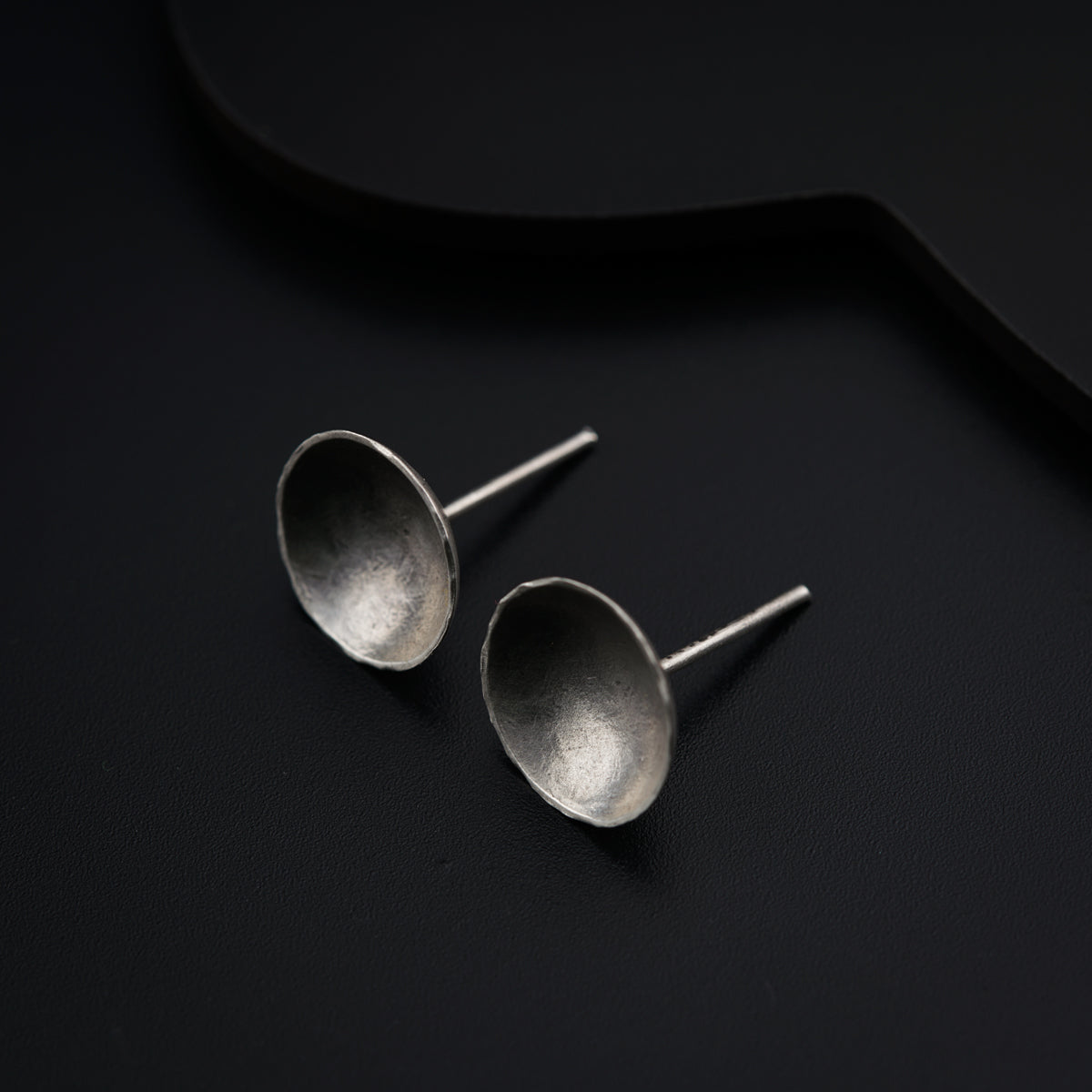 a pair of silver spoons sitting on top of a black surface