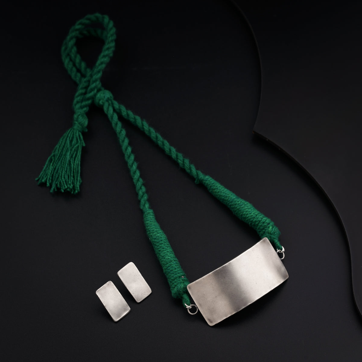 a green cord with a metal tag attached to it