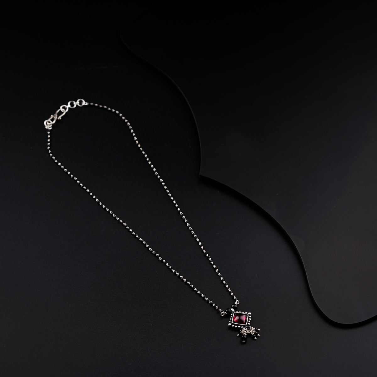 a necklace with a cross on a black background