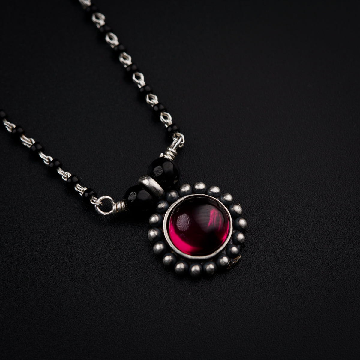 a close up of a necklace on a black surface