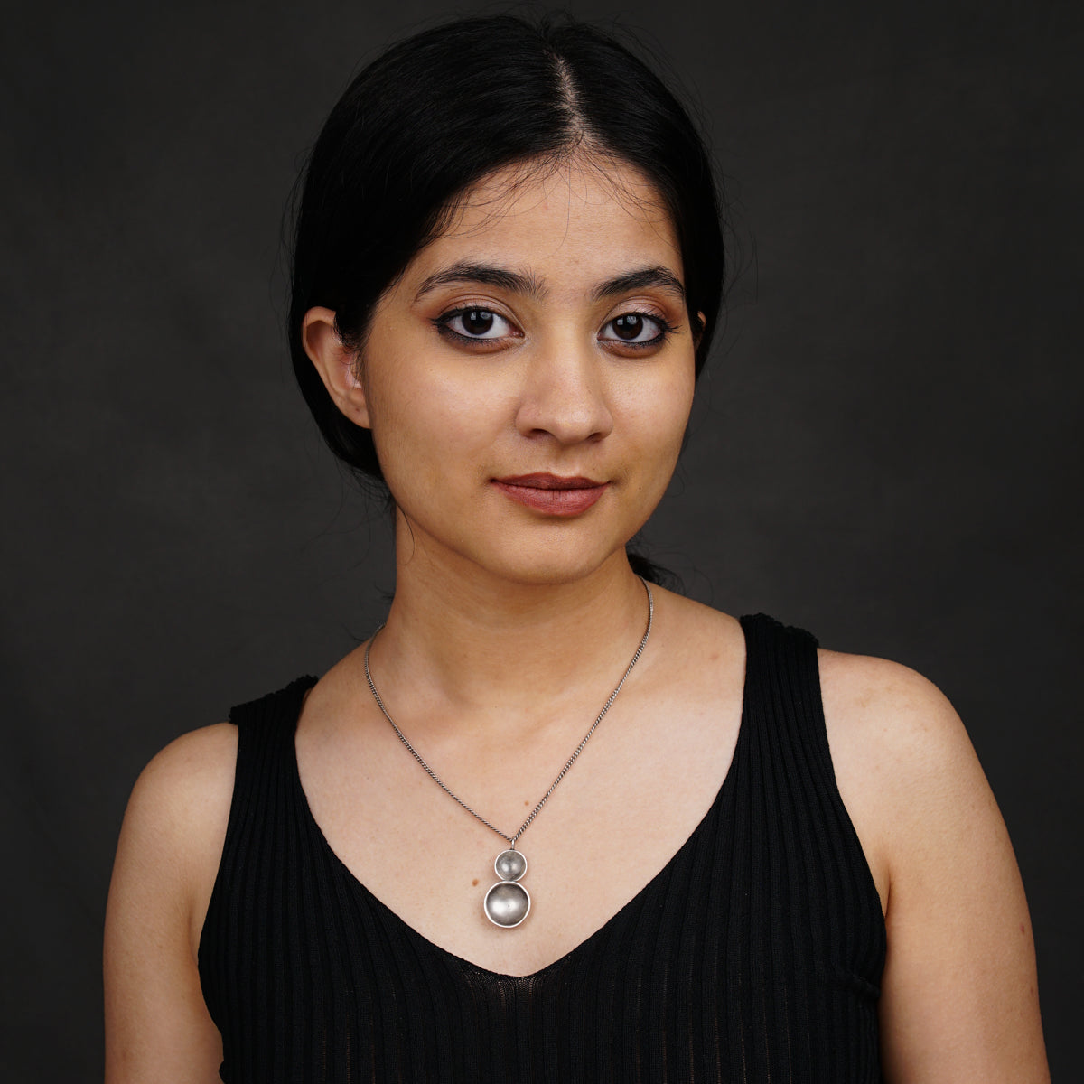a woman wearing a black shirt and a necklace
