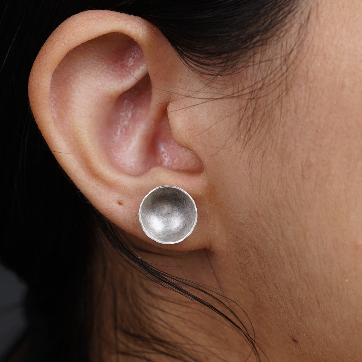 a close up of a person wearing a pair of earrings