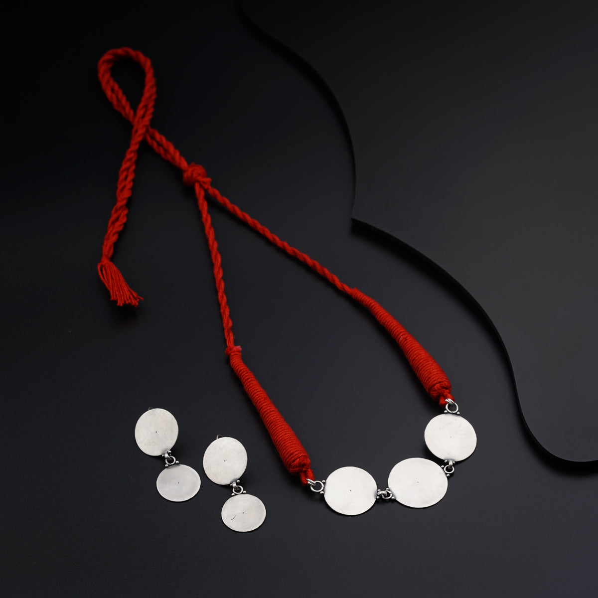 a red cord with three white discs on it
