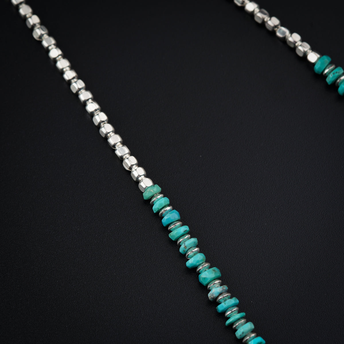a necklace with a turquoise bead and silver beads