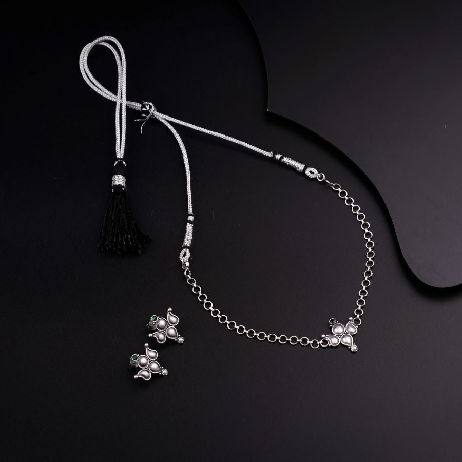 a black and white photo of a necklace and a tassel