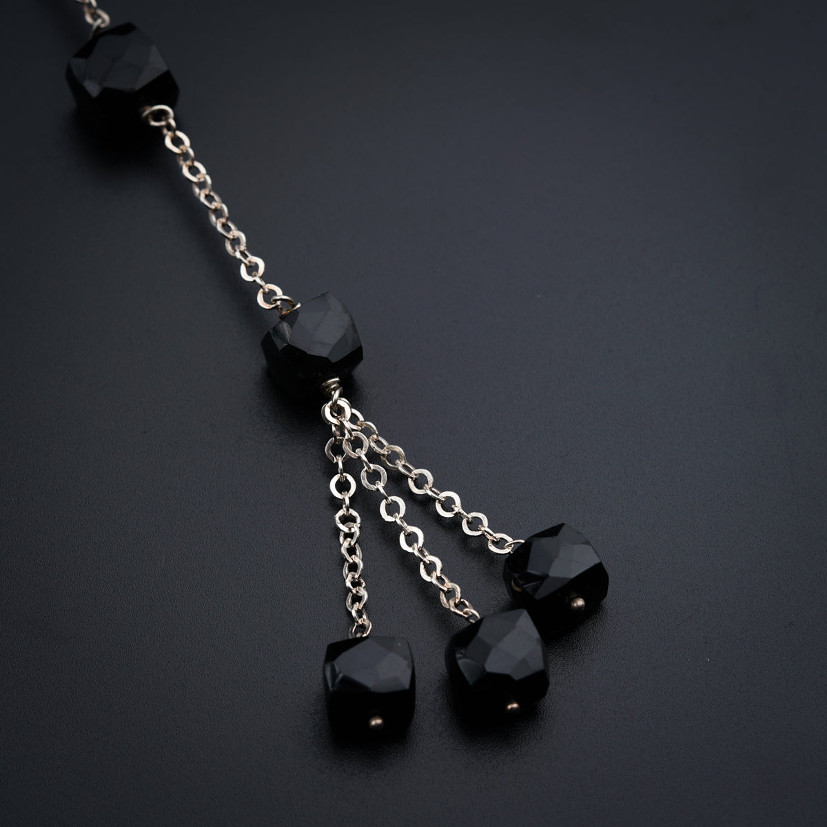 a chain with black beads hanging from it