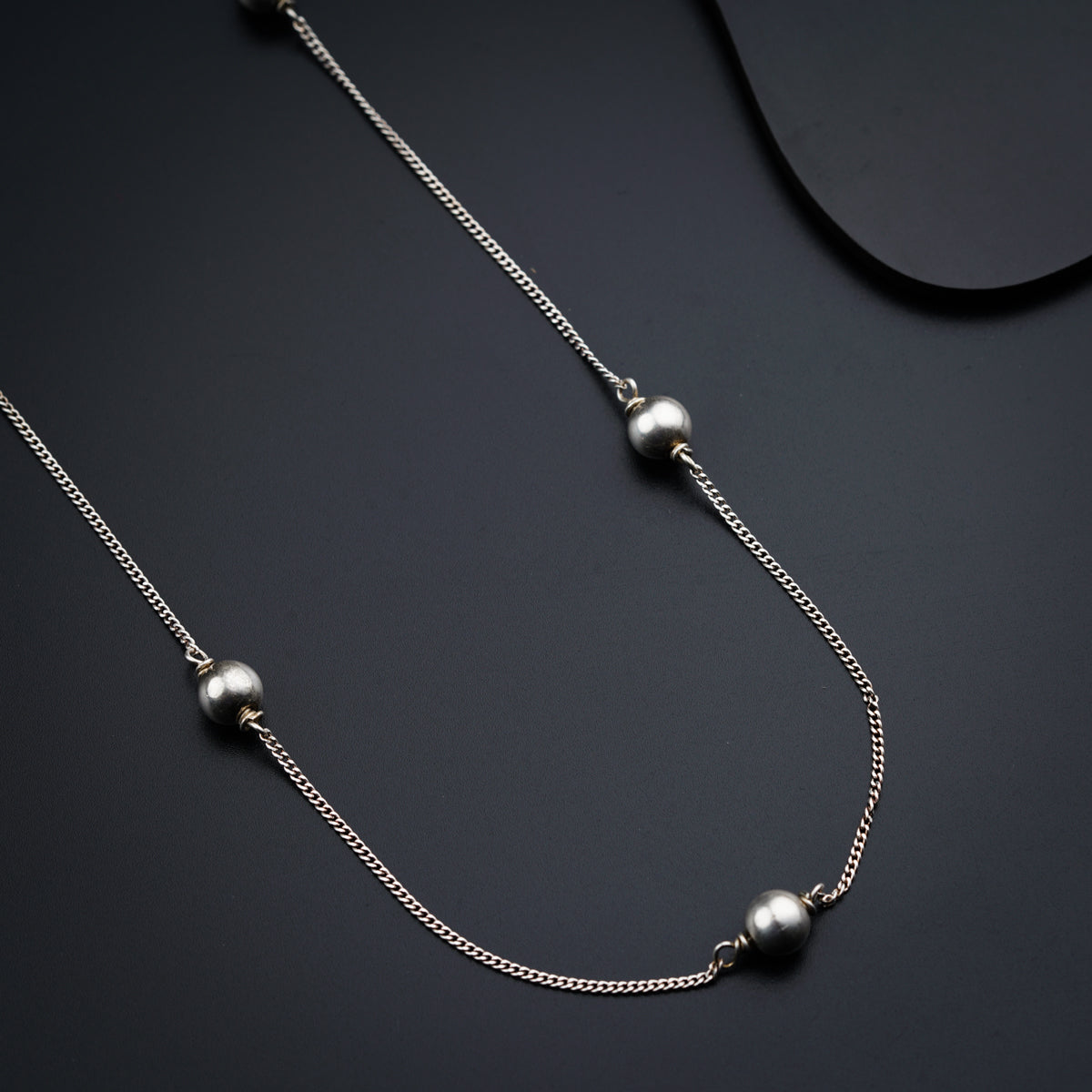 a close up of a necklace on a black surface