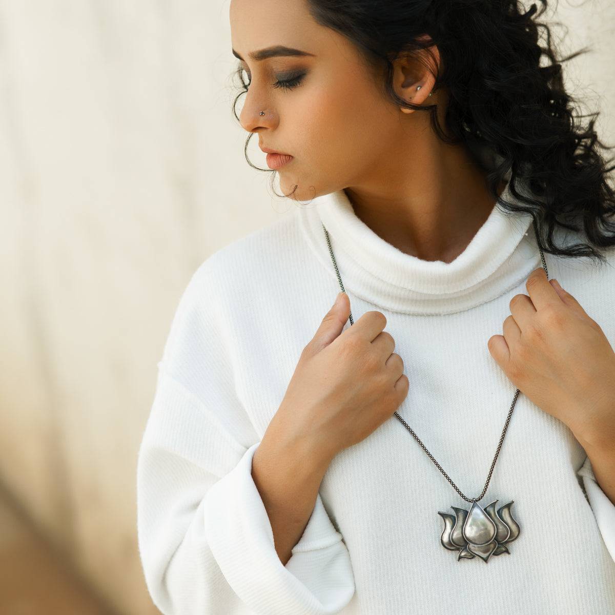 a woman wearing a white turtle neck sweater