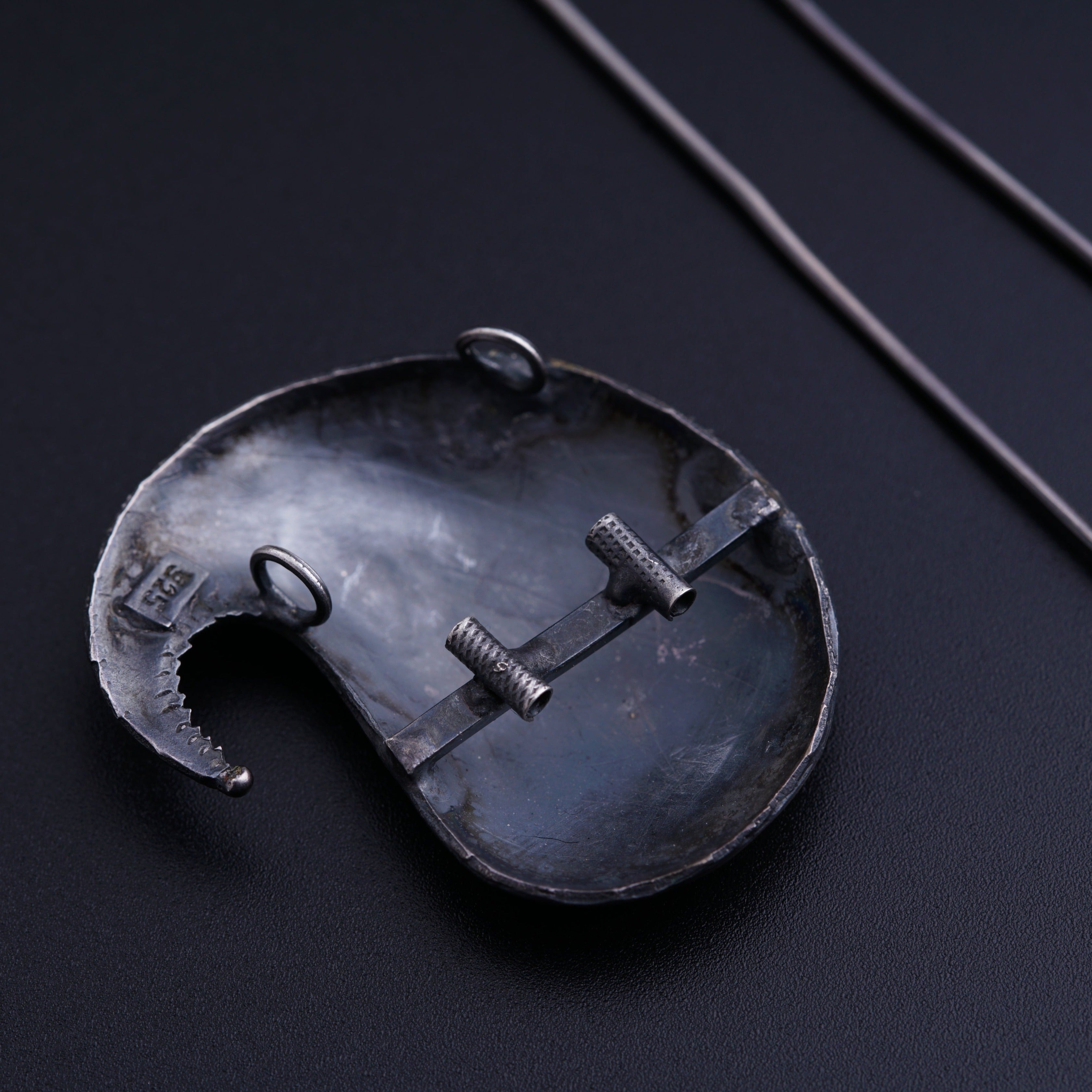 a metal object on a black surface