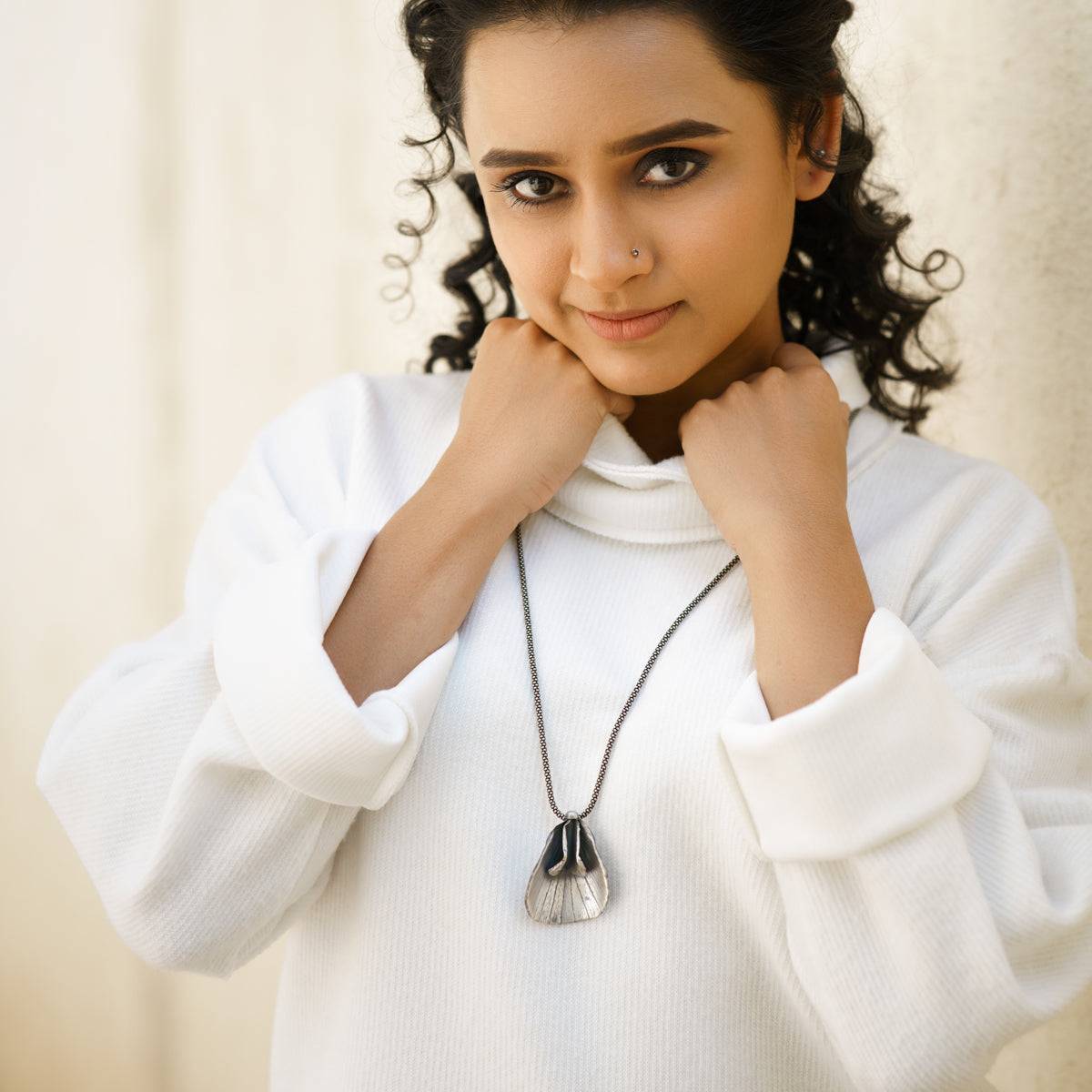 a woman wearing a white sweater posing for a picture
