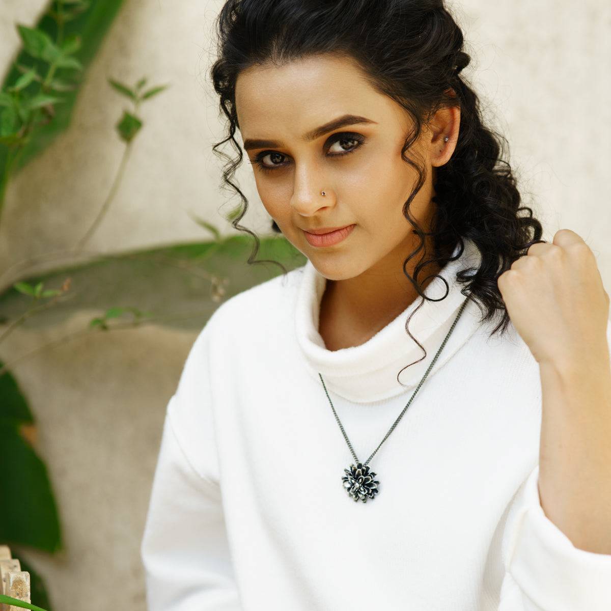 a woman wearing a white sweater and a necklace