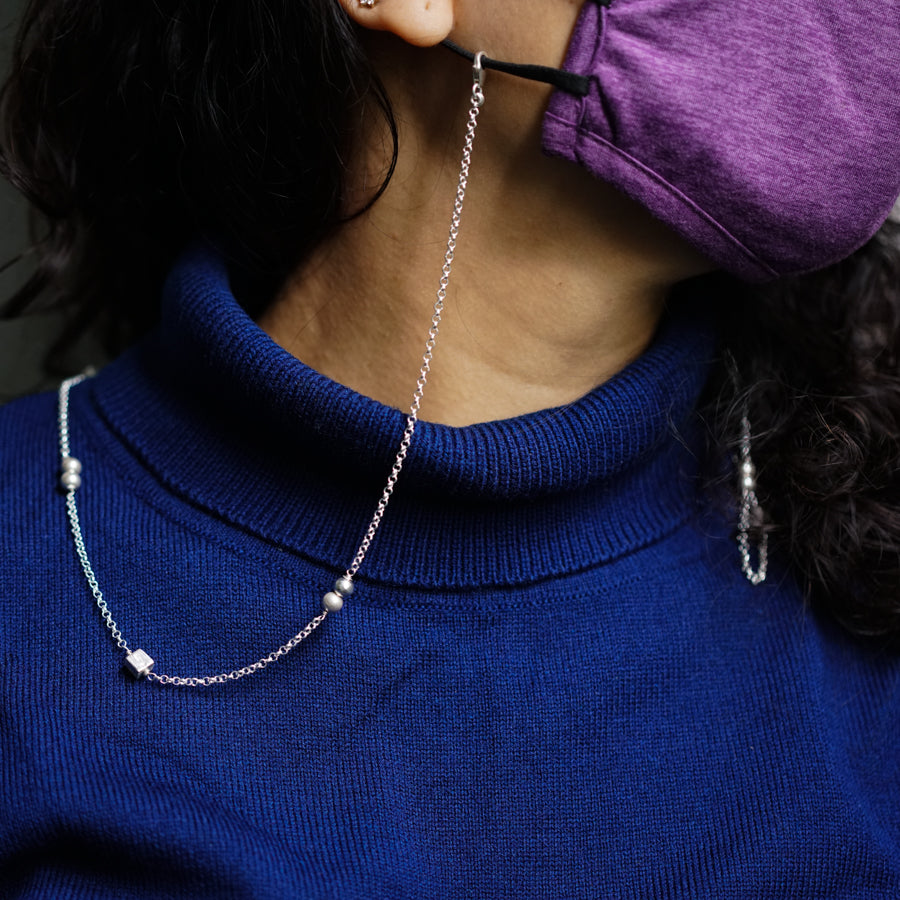 a woman wearing a blue sweater is talking on a cell phone