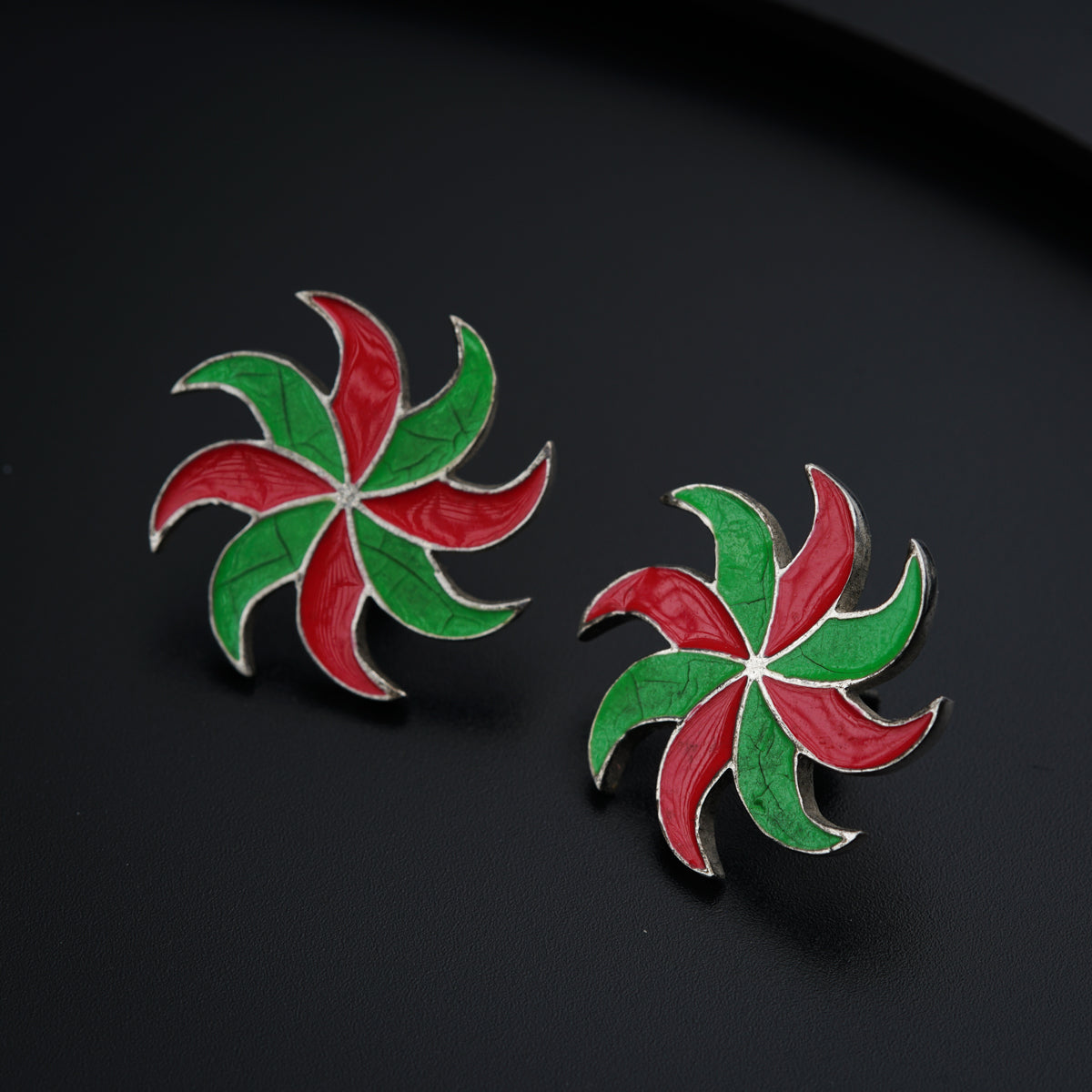 a pair of red, green and white flower shaped earrings