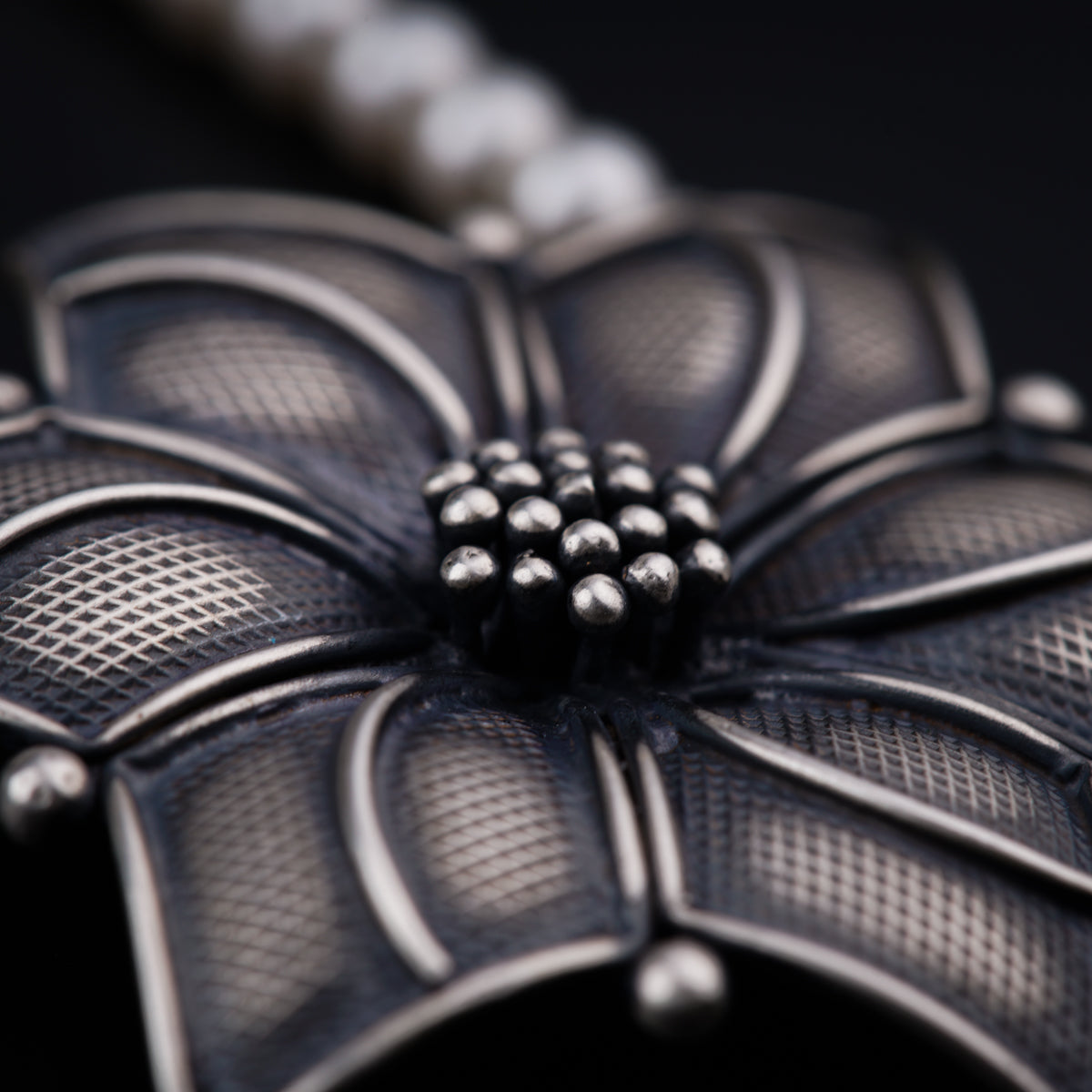 a close up of a flower shaped object on a chain