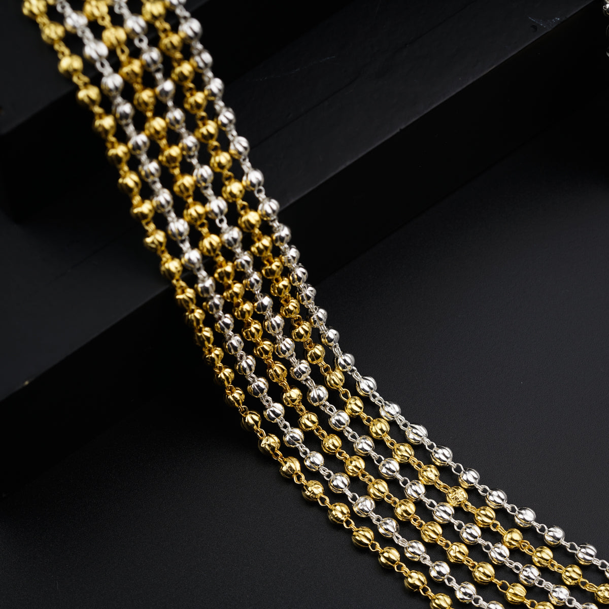 a gold and silver chain on a black surface