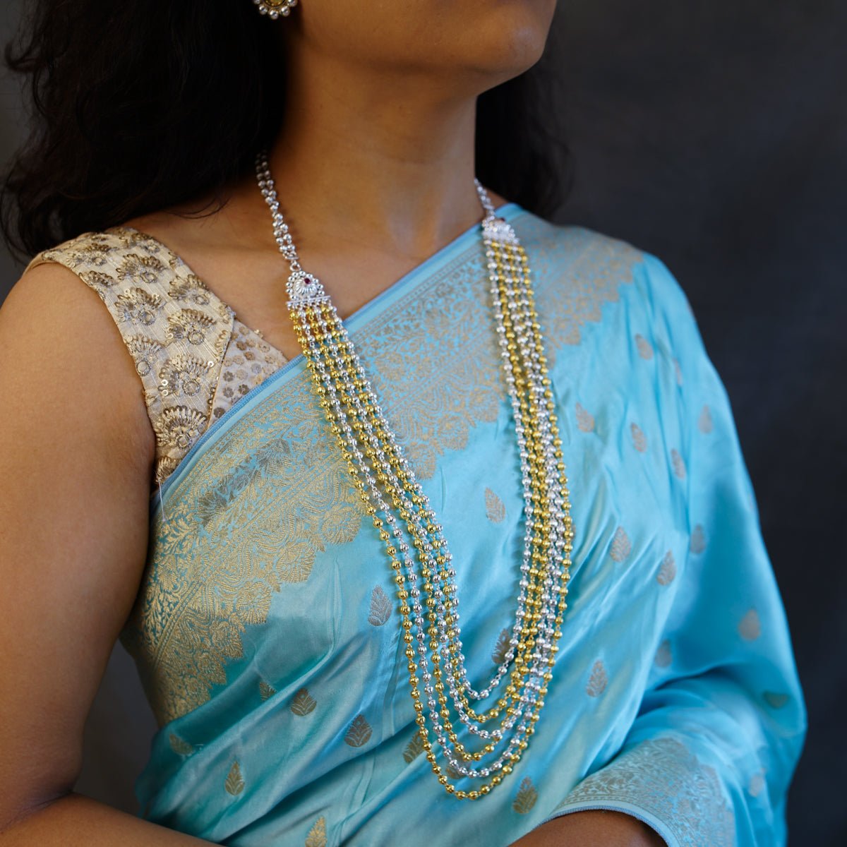 a woman wearing a blue sari and a necklace