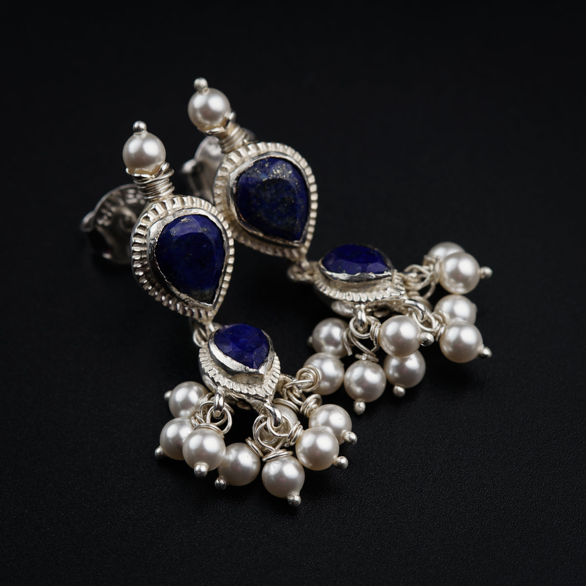 a close up of a pair of blue and white earrings