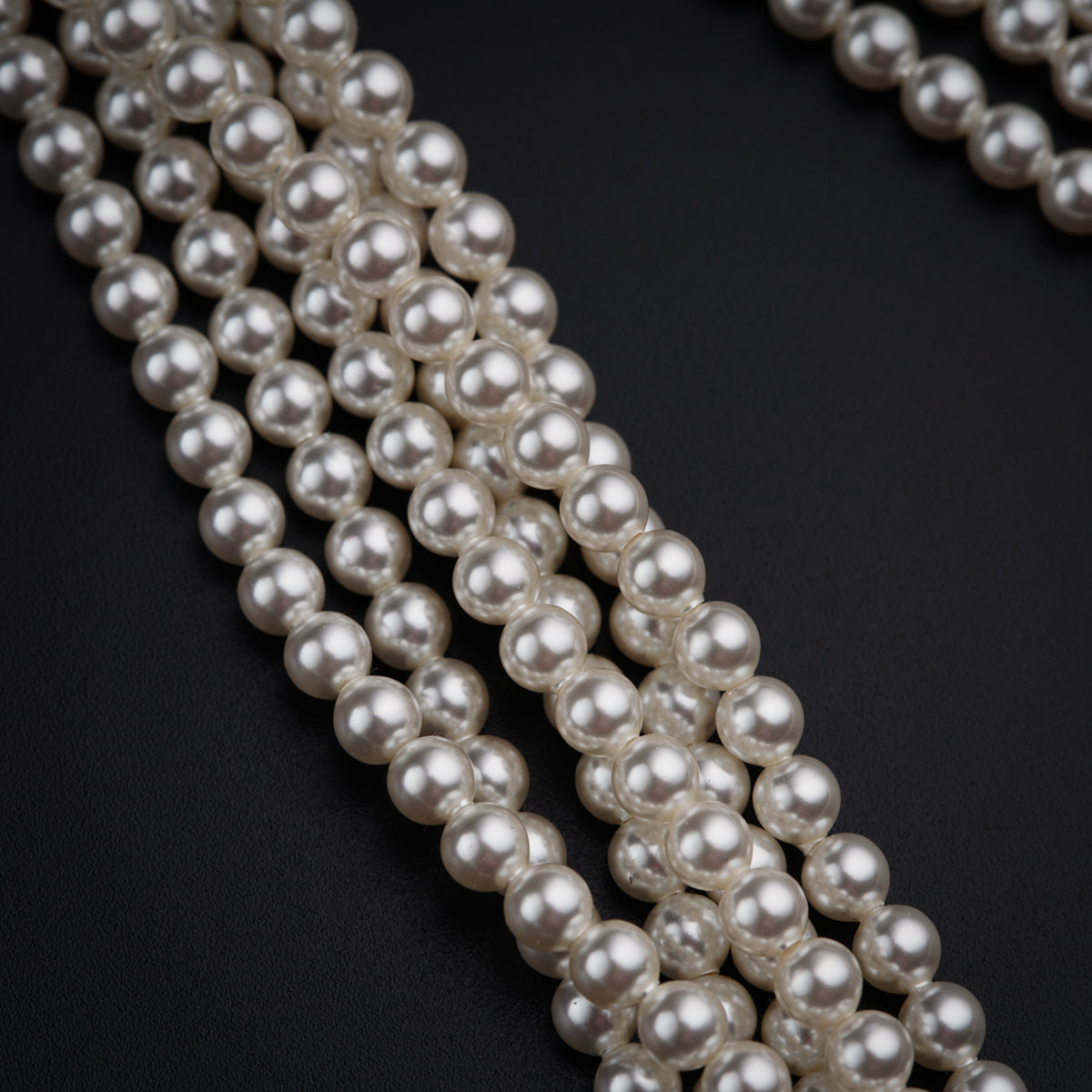a close up of pearls on a black surface