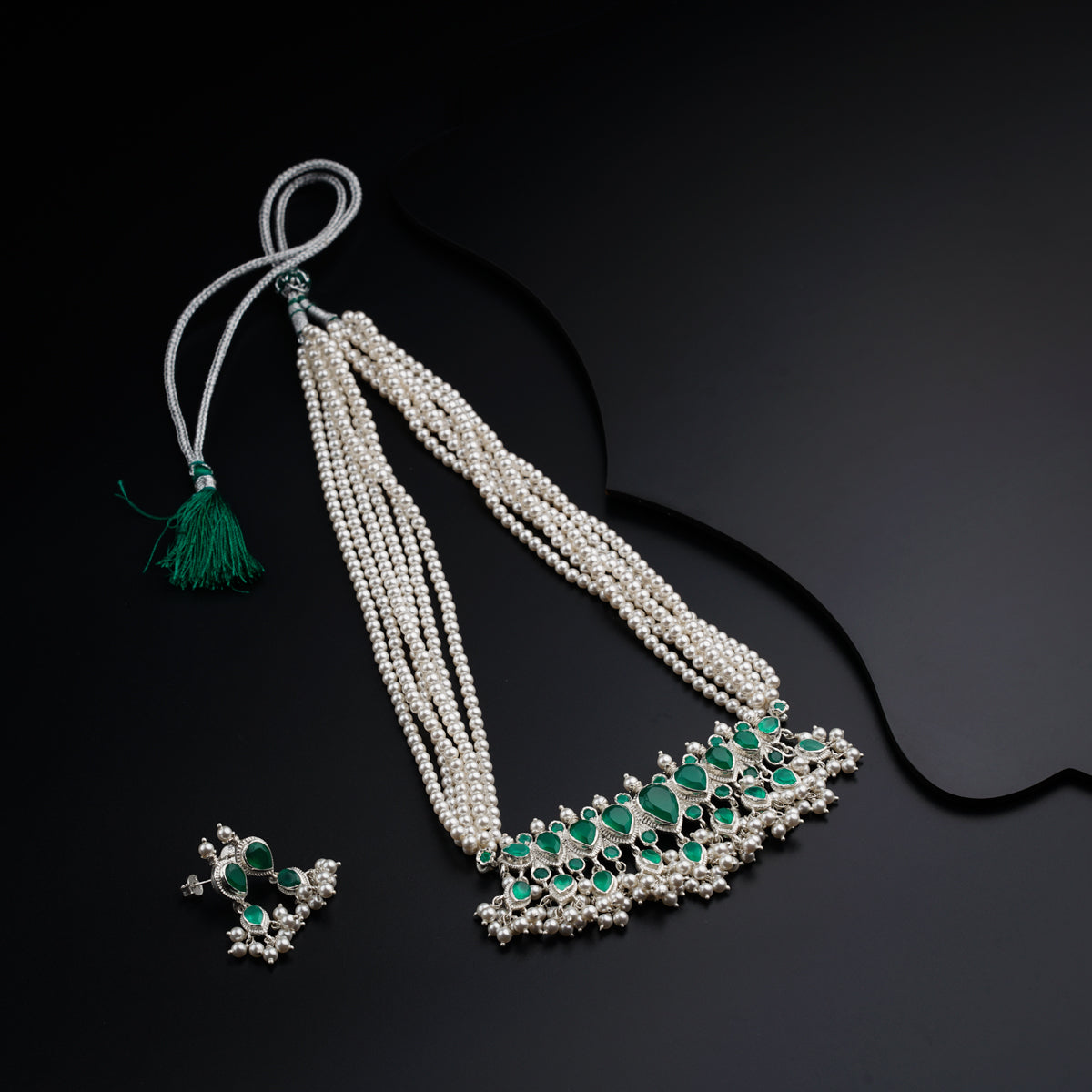 a necklace and earring with pearls and emeralds