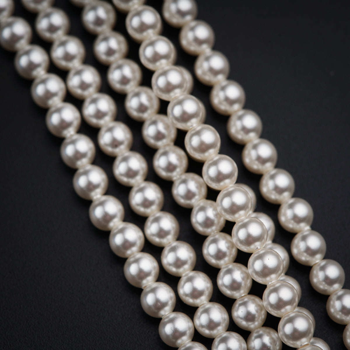 a close up of pearls on a black surface