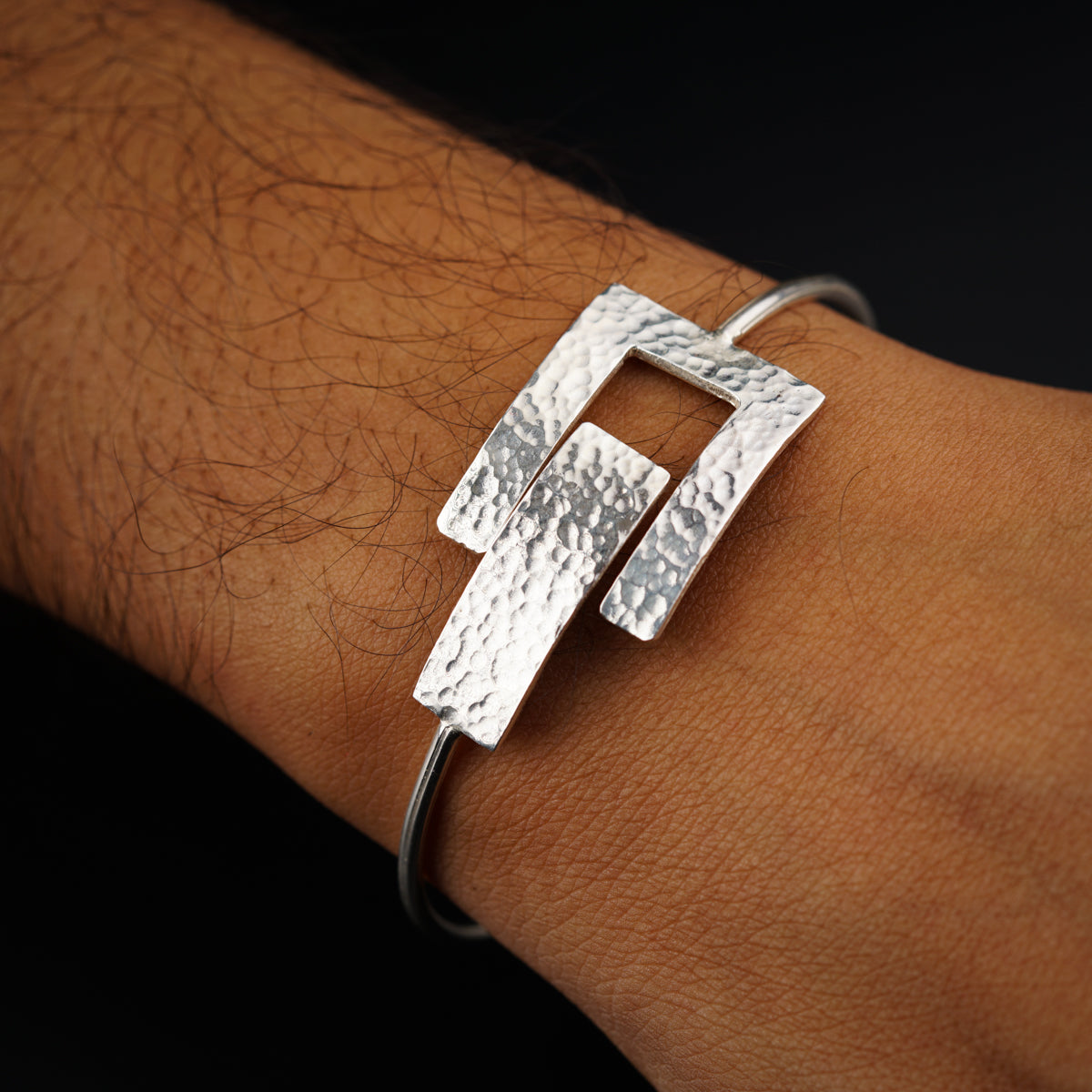a person's arm with a silver bracelet on it