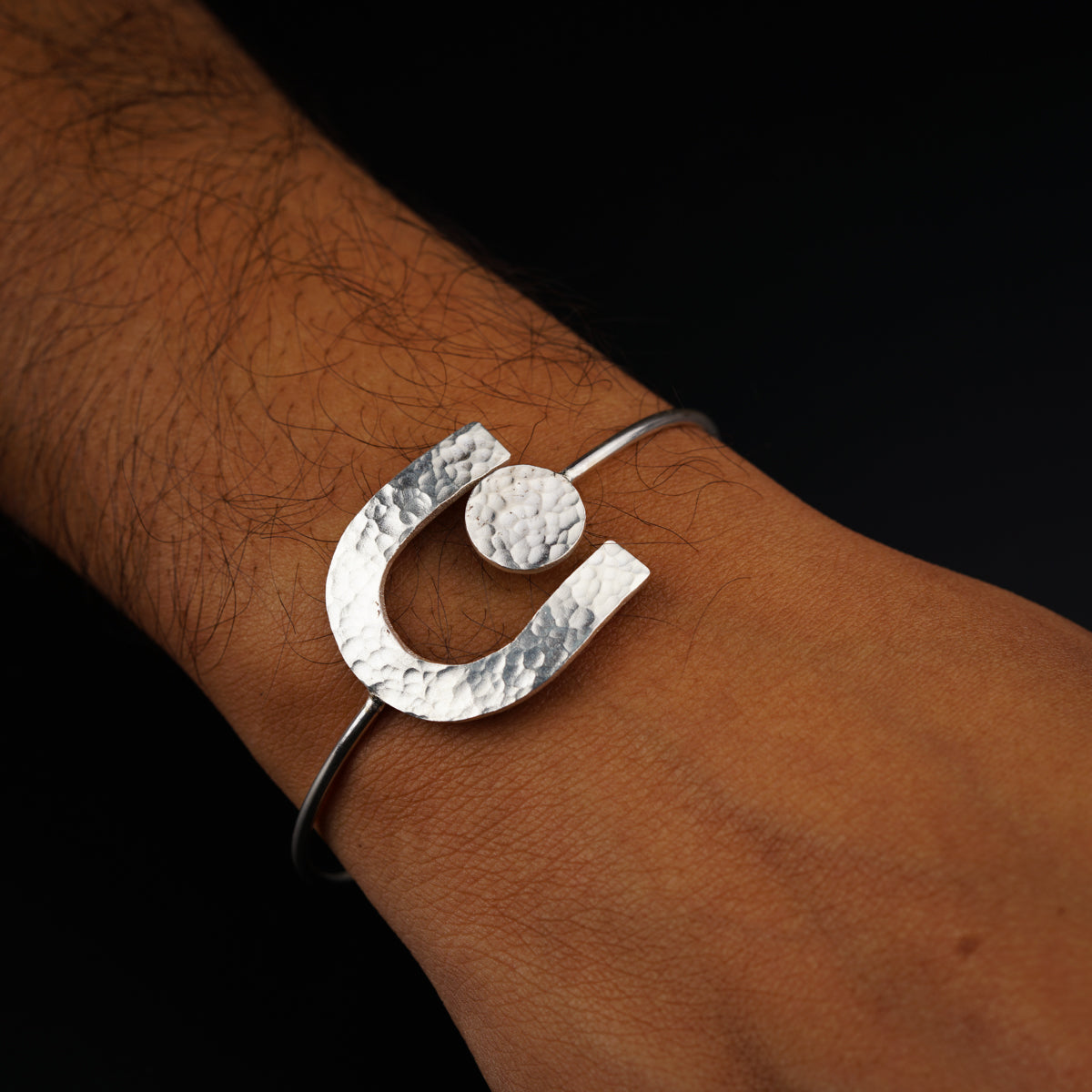 a person's arm with a silver bracelet on it