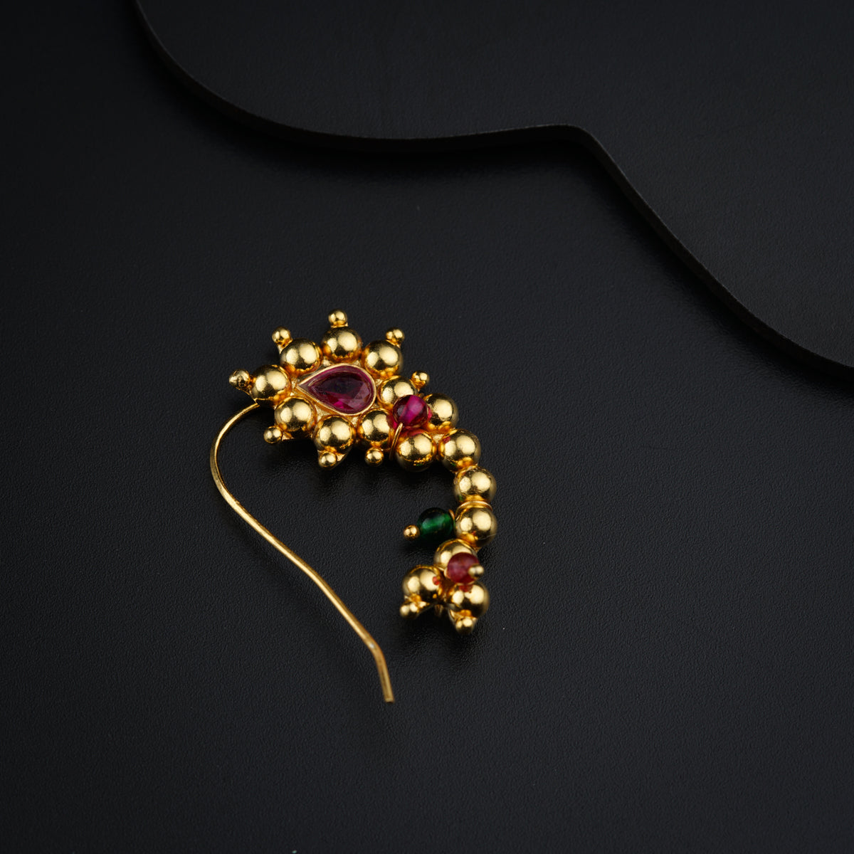 a close up of a brooch on a black surface