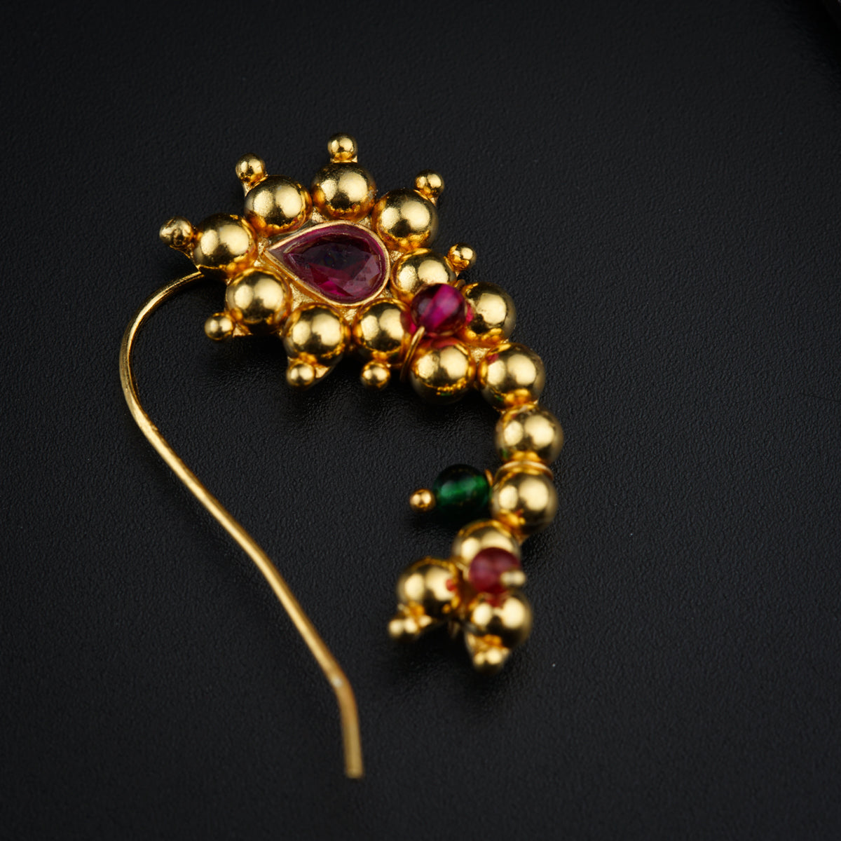 a close up of a brooch on a black surface