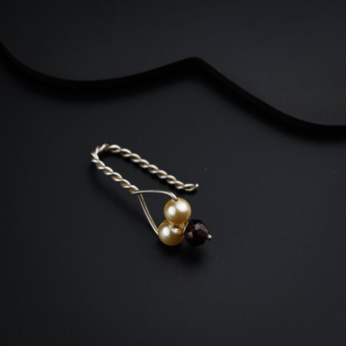 a pair of pearls and a chain on a black surface