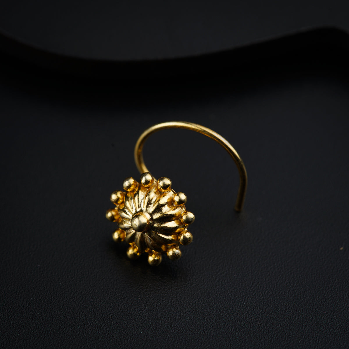 a close up of a gold ring on a black surface