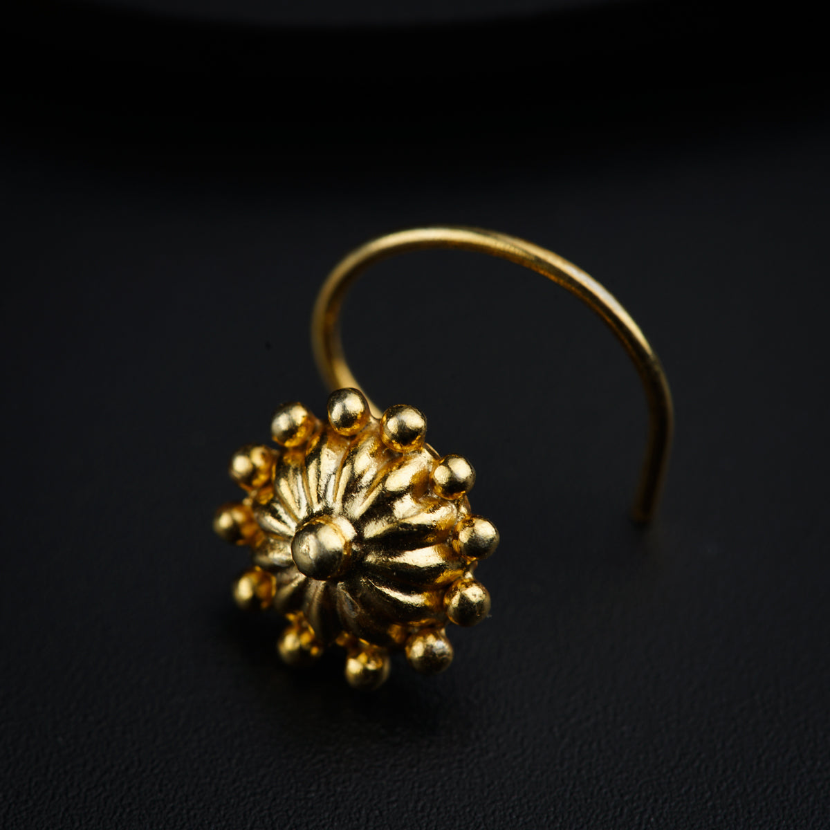 a close up of a gold ring on a black surface