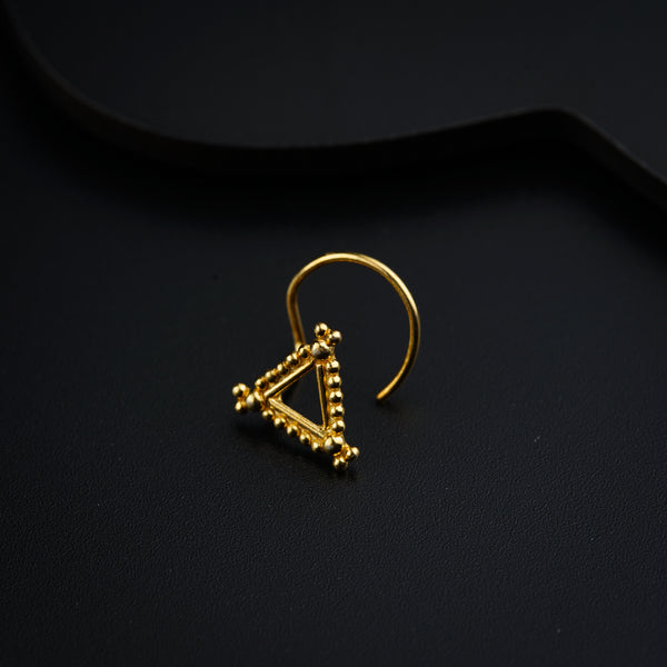 a pair of gold earrings on a black surface