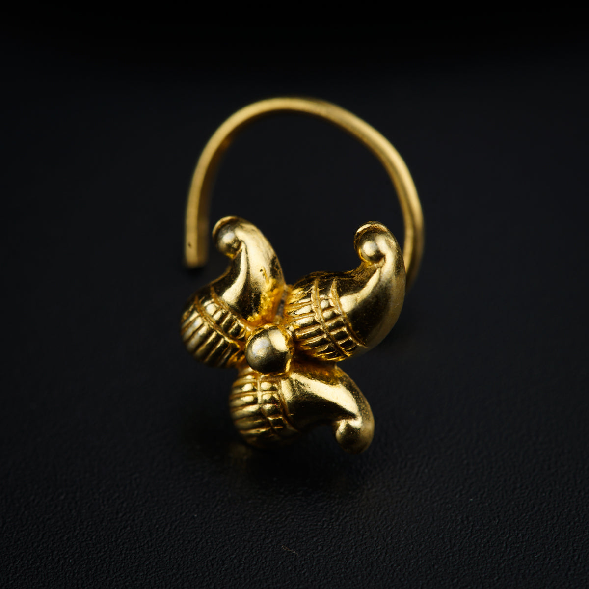 a close up of a gold ring on a black surface