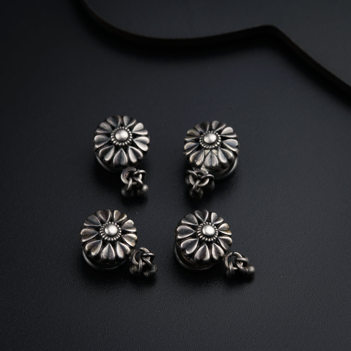 a pair of silver earrings sitting on top of a table