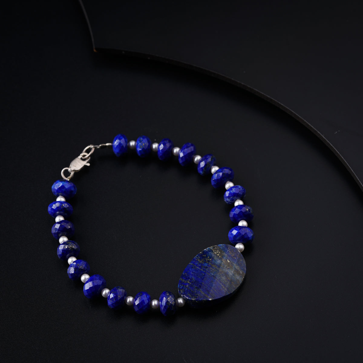 a blue beaded bracelet with a tear shaped stone