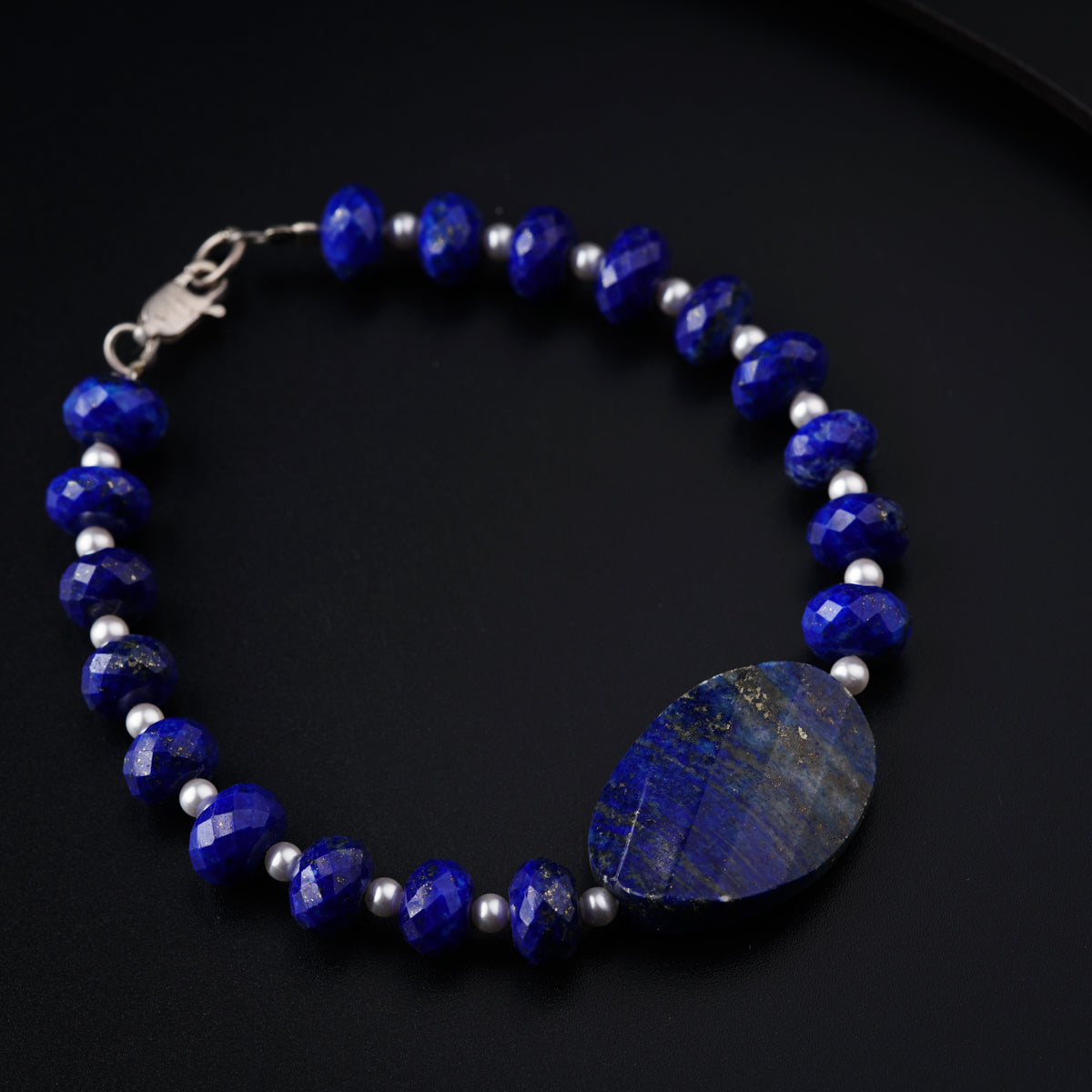 a blue beaded bracelet with a heart shaped stone