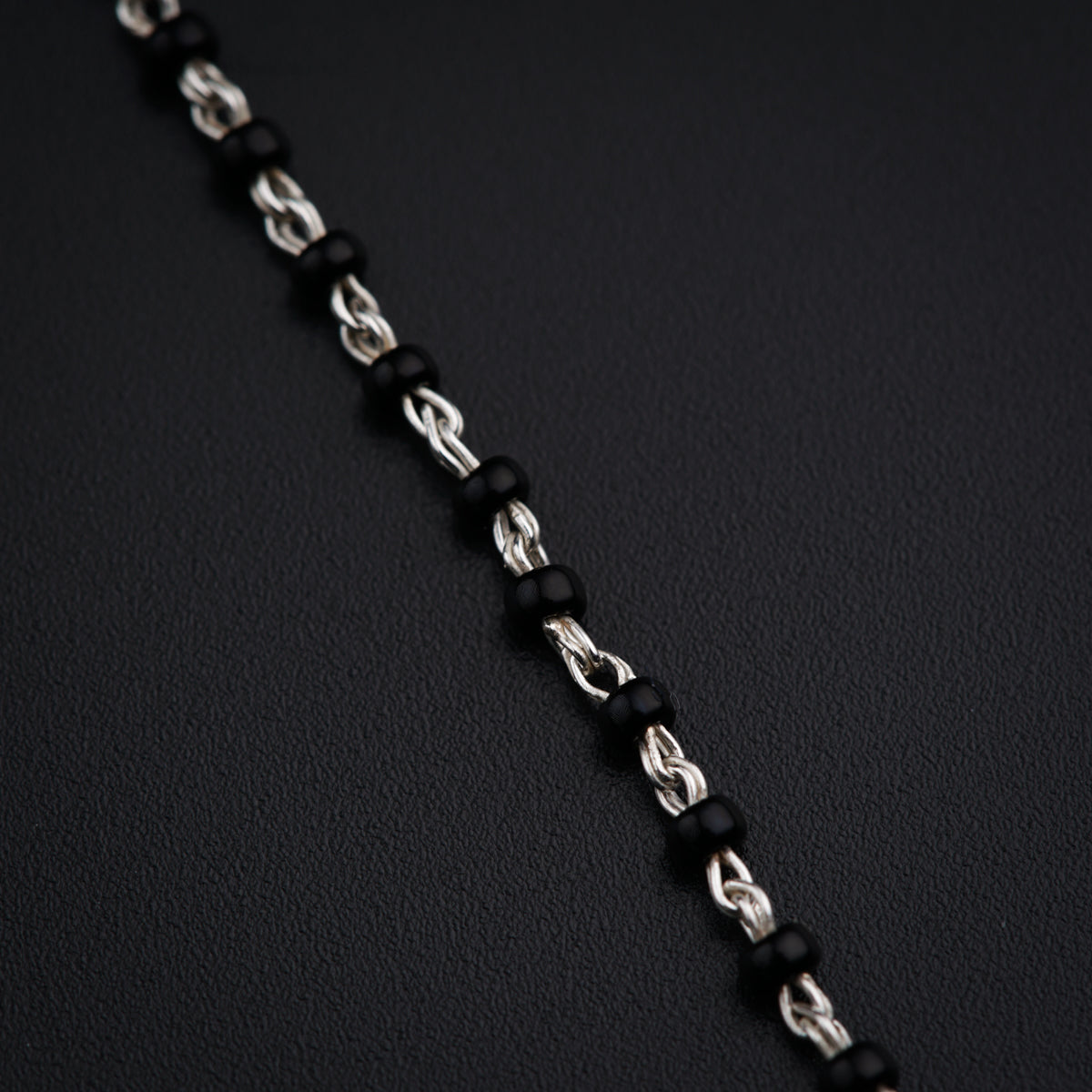 a close up of a chain on a black surface