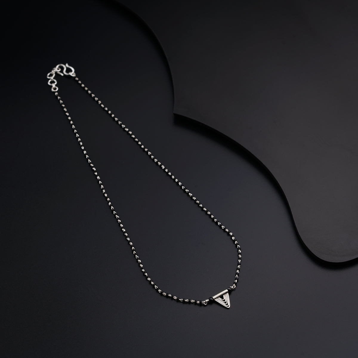a necklace with a triangle on a chain