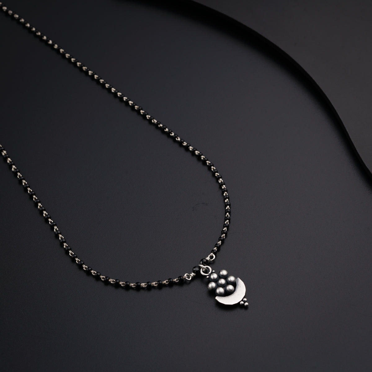 a necklace with a cat and a moon on it