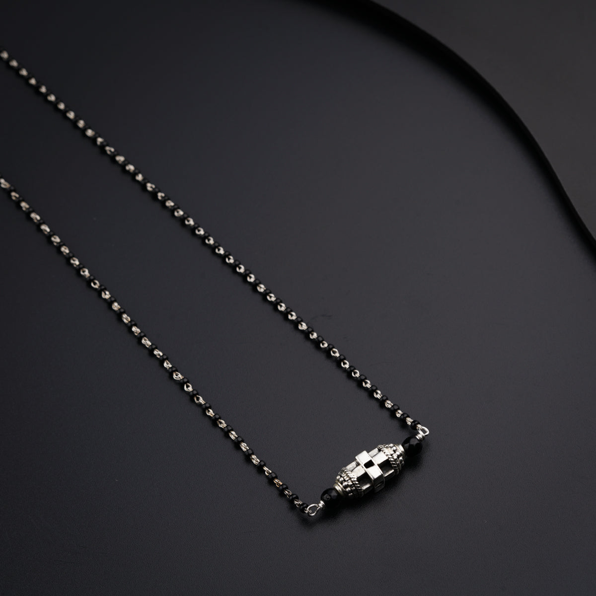 a black and silver necklace with a skull on it