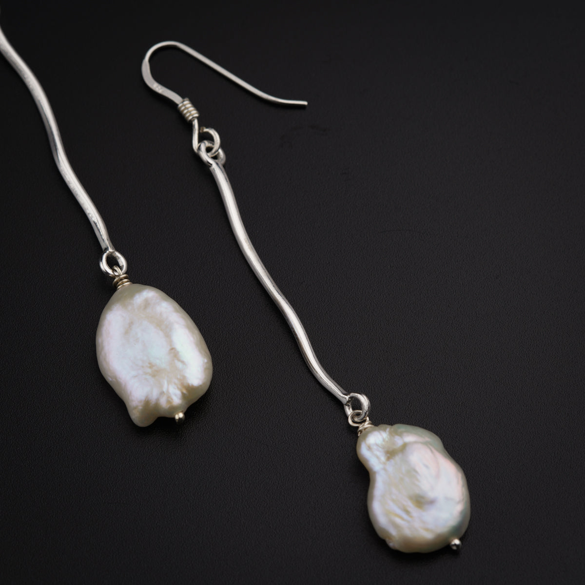 a pair of earrings with a white pearl