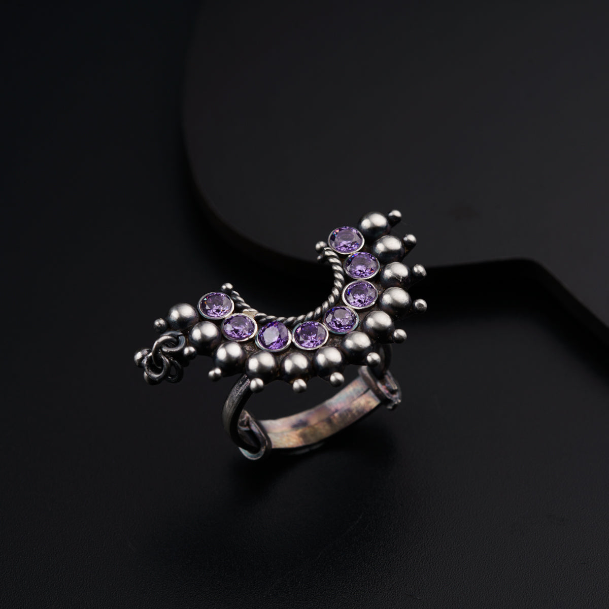a silver ring with purple stones on it